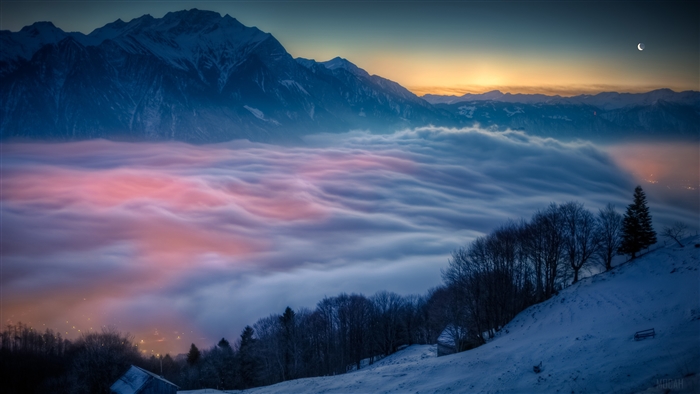 Mountain landscape with mist and snow at sunset