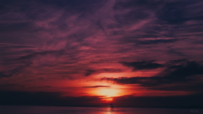 Sunset over the sea with flares and reflection