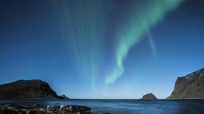 Aurora Borealis over a rocky beach at night