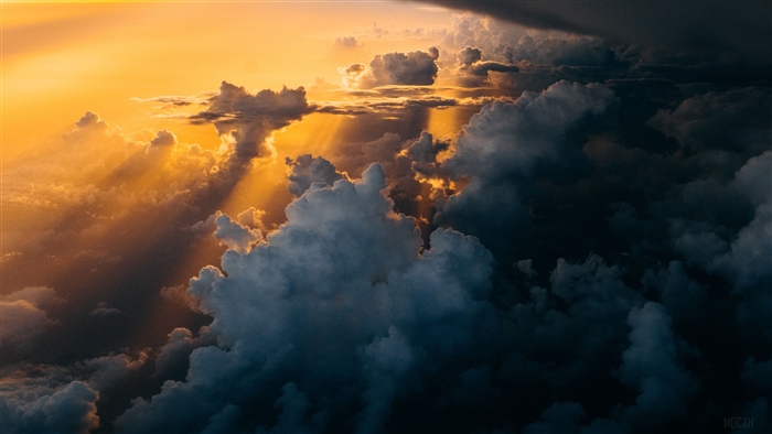 Sunlight beams through dark and bright clouds