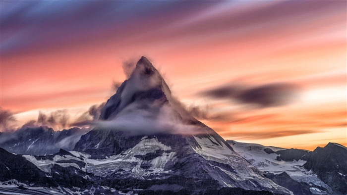 Snowcapped Mountain Peak with Clouds at Sunset