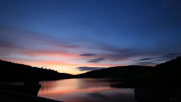 Sunset over a lake with mountains and trees