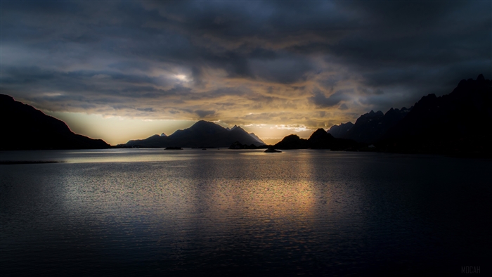 Mountains and lake at dusk with dramatic clouds