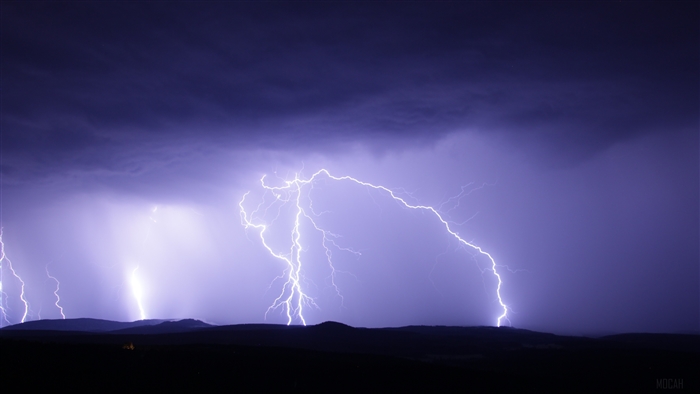 Lightning strikes over dark hills during a thunderstorm 4K