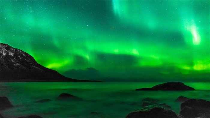 Northern Lights over a rocky coast 4K