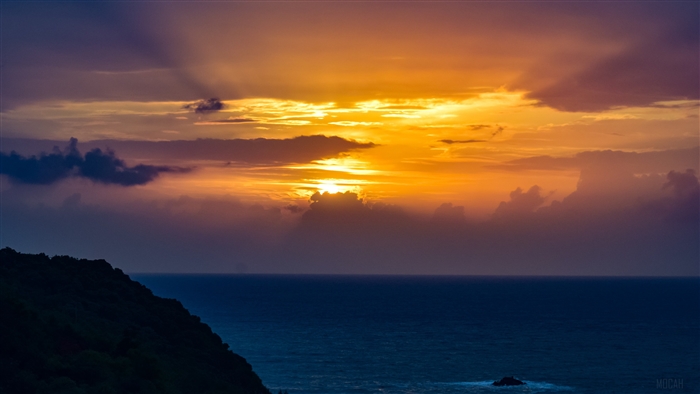 Sunset over the ocean with dramatic clouds