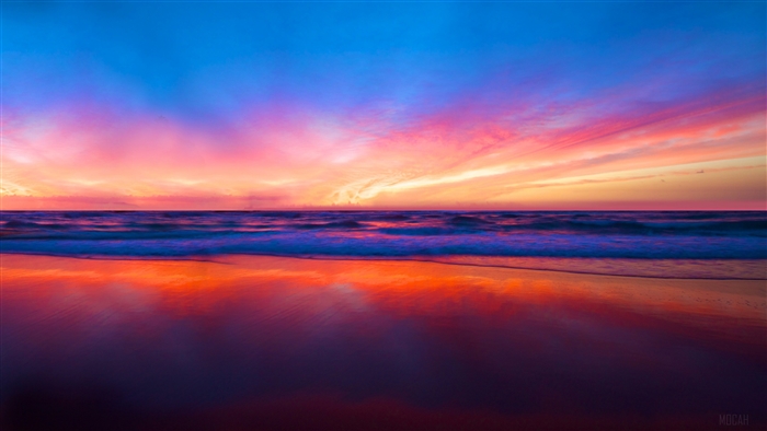 Sunset over the ocean with colorful clouds and reflection