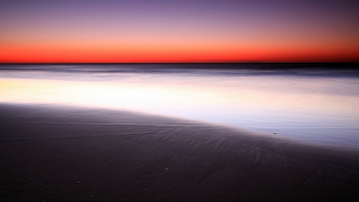 Beach at sunset with calm ocean waves