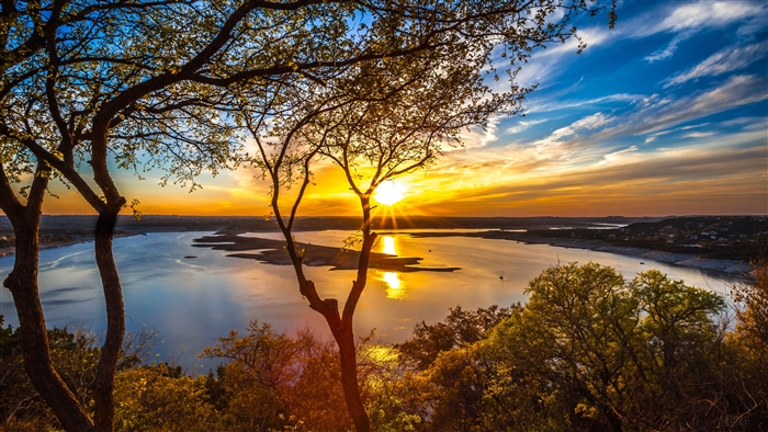 Sunset over Lake Travis with trees in foreground