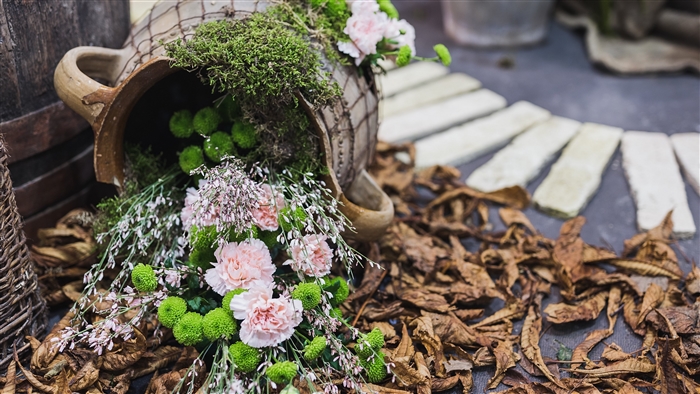 Flower arrangement in a jug with dried leaves