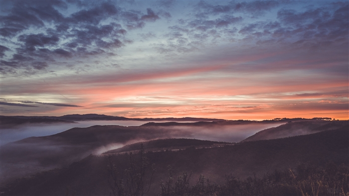 Sunrise over misty mountains with colorful sky