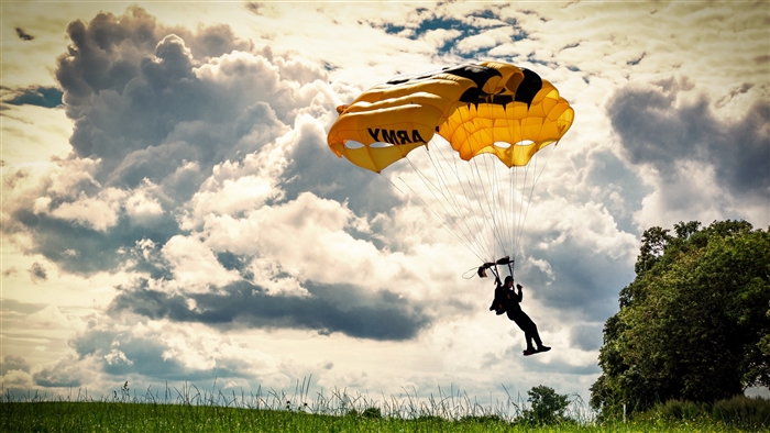 Parachutist with Army Parachute under Clouds