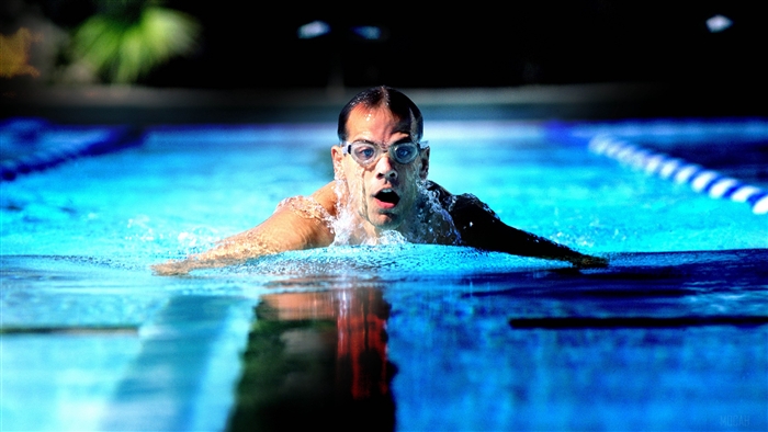 Man swimming butterfly stroke in a pool 4K