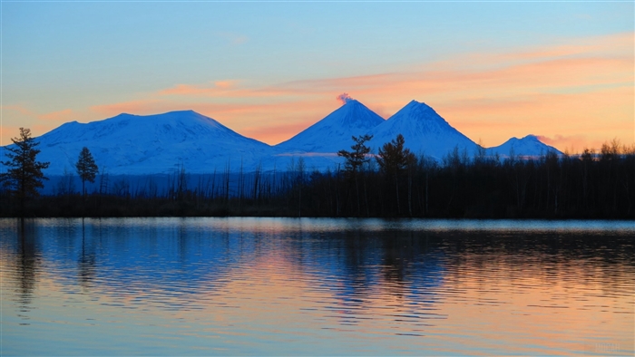 Volcanoes reflecting in a lake at sunrise