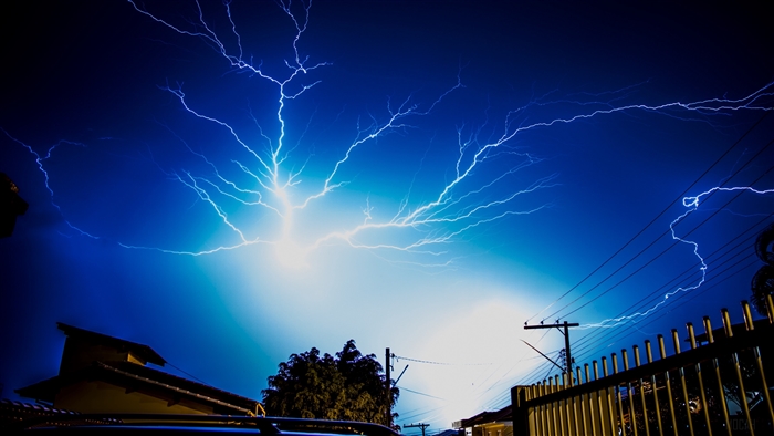 Lightning strikes in a dark blue sky at night