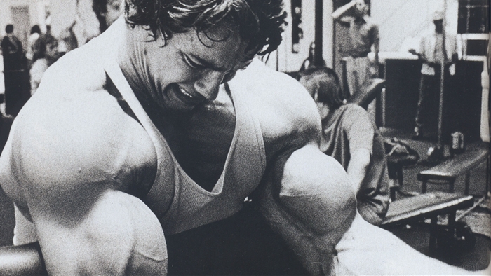 Arnold Schwarzenegger bodybuilding in a gym