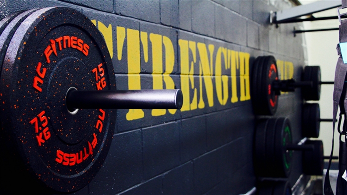 Gym wall with weight plates and the word STRENGTH