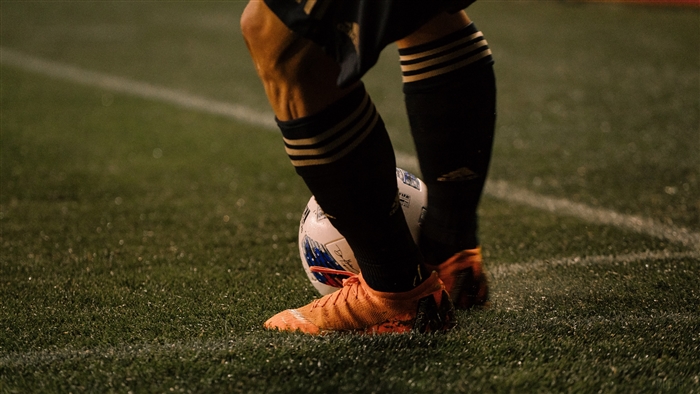 Footballer with ball on grass field