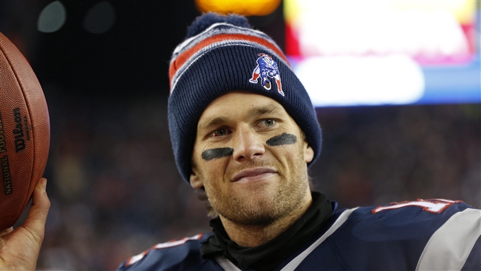 Tom Brady of the New England Patriots holding a football
