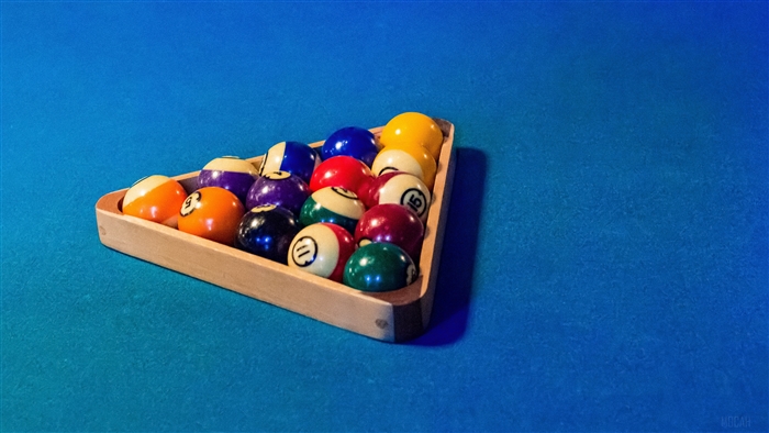 Billiard balls in a triangle rack on a blue table 4K