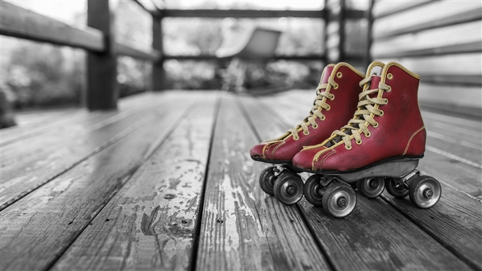 Red Retro Roller Skates on Wooden Deck