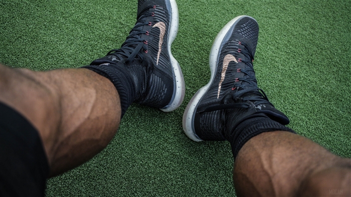 Man's legs with Nike sneakers on green turf