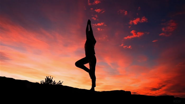 Silhouette of a person doing yoga at sunset