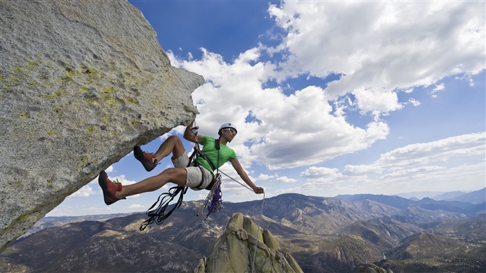 Man rock climbing on a cliff with rope