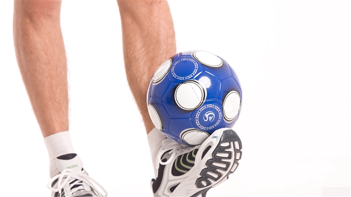 Person balancing blue soccer ball on foot in white background 4K