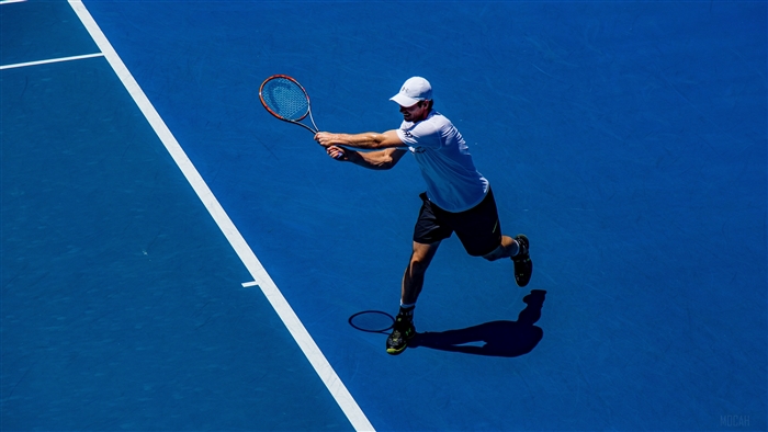 Tennis player hitting a forehand on a blue court