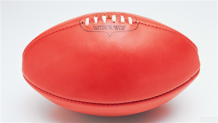 Red football with white laces on white background 4K