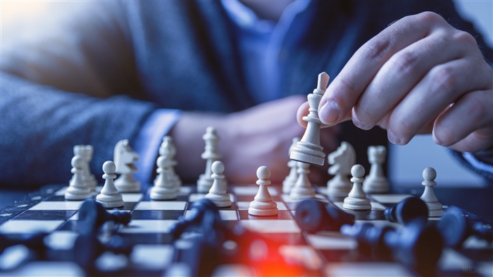 Chess game with a hand moving a white king piece