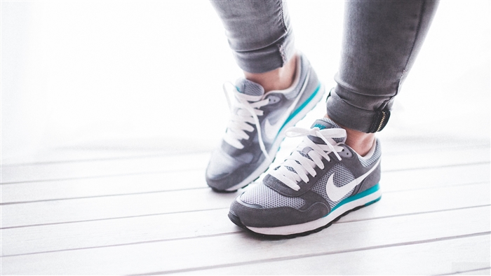 Nike sneakers on legs in grey jeans 4K