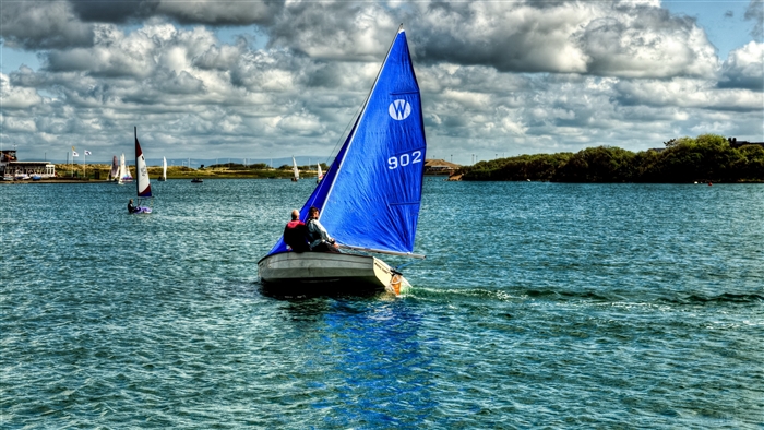Sailboats on a lake under a cloudy sky