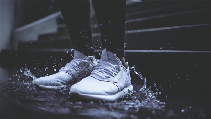 White sneakers splashing in water