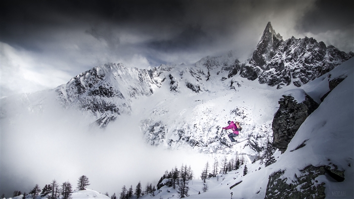 Skier jumping over a snowy mountain landscape in 4K