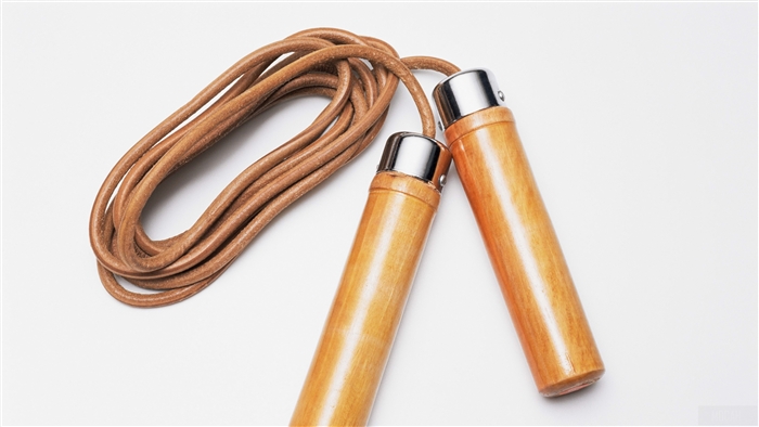 Leather jump rope with wooden handles on white background