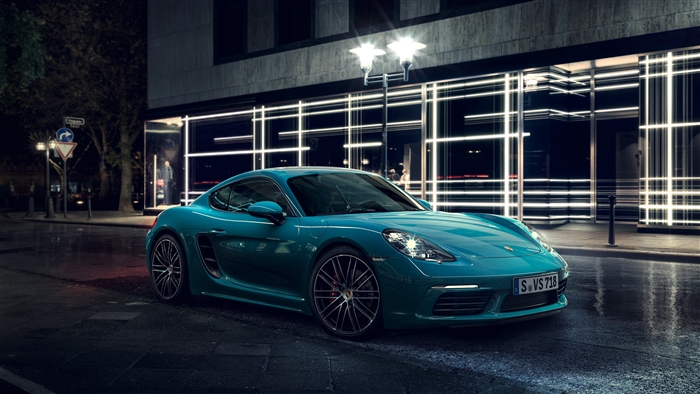Teal Porsche Cayman S on wet street at night