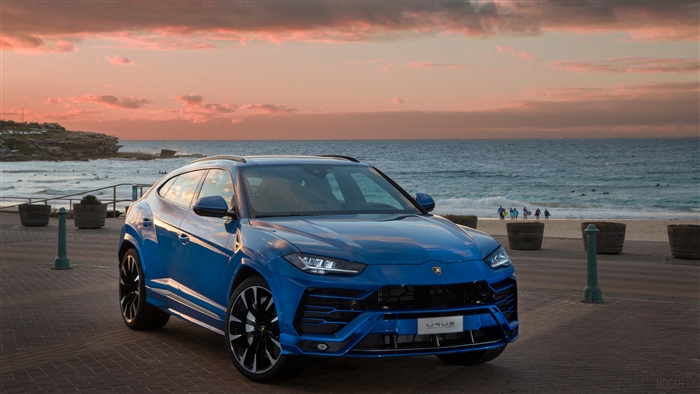 Blue Lamborghini Urus on Beach Boardwalk at Sunset