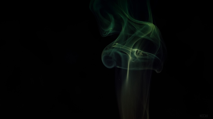 Green smoke swirling against a black background