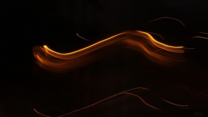 Wavy orange light trails on dark background 4K