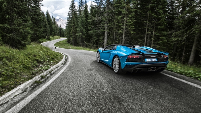 Blue Lamborghini Aventador S driving on a mountain road