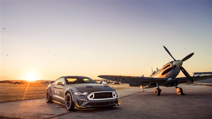Ford Mustang GT and Spitfire airplane at sunset