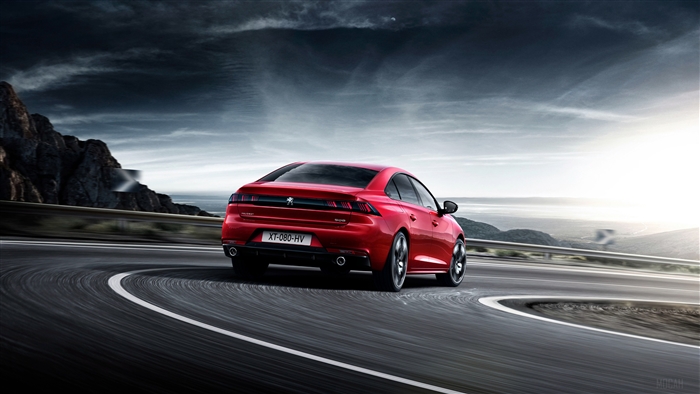 Red 2018 Peugeot 508 GT driving on a winding road