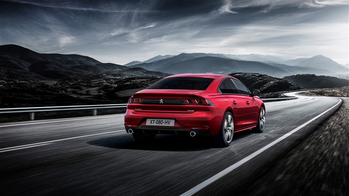 Red Peugeot 508 GT driving on a winding road