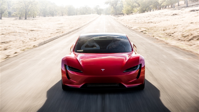 Red Tesla Roadster driving on a road