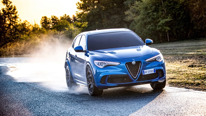 Blue Alfa Romeo Stelvio Quadrifoglio driving on wet road