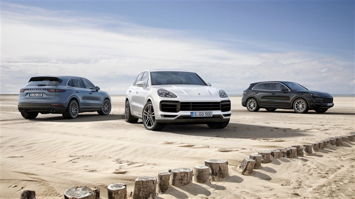 Three Porsche Cayenne SUVs on a Sandy Beach