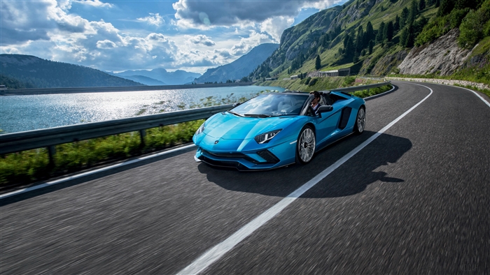 Blue Lamborghini Aventador S Roadster driving on mountain road