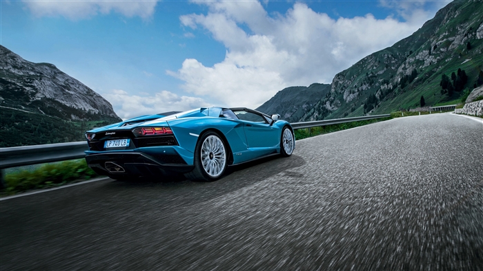 Blue Lamborghini Aventador S Roadster driving on mountain road